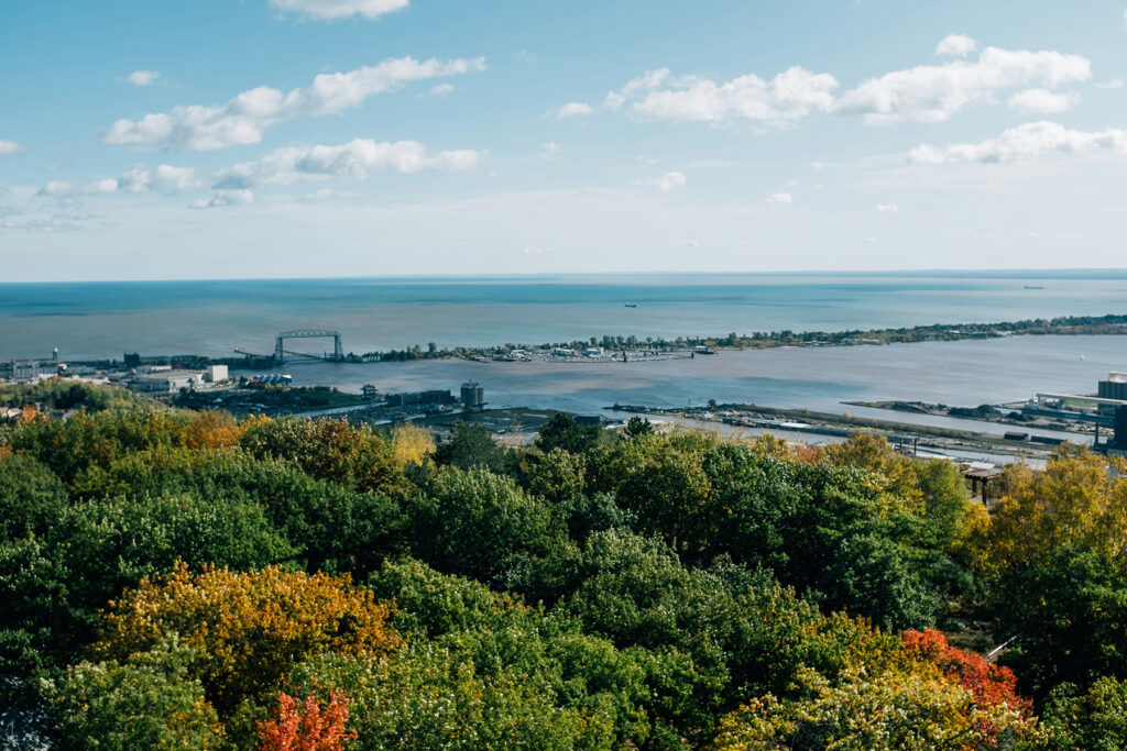 An autumn skyline view of Lake Superior in Duluth, Minnesota, with vibrant fall foliage.